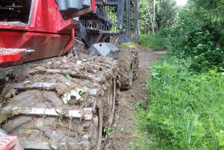 Komatsu 840TX mit erdigen Ketten und Reifen.